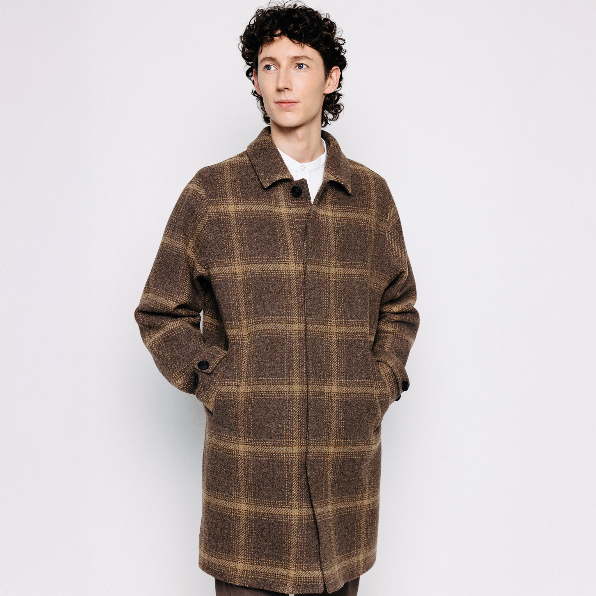 Maður í brúnum köflóttum ullarfrakka frá Thomsen Reykjavík.