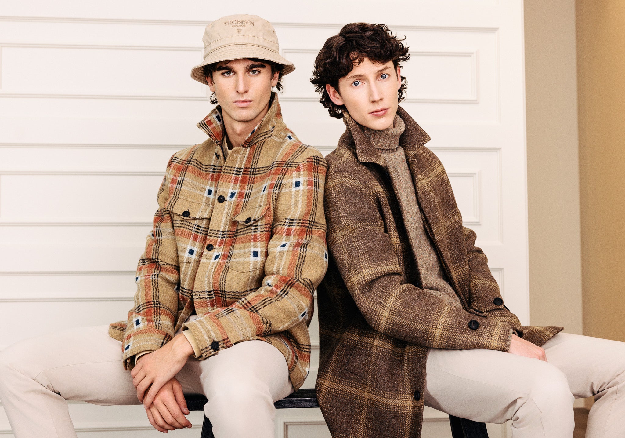 Tveir ungir menn í yfirskyrtu og frakka úr ull. Ljósum buxum og rúllukragapeysu.