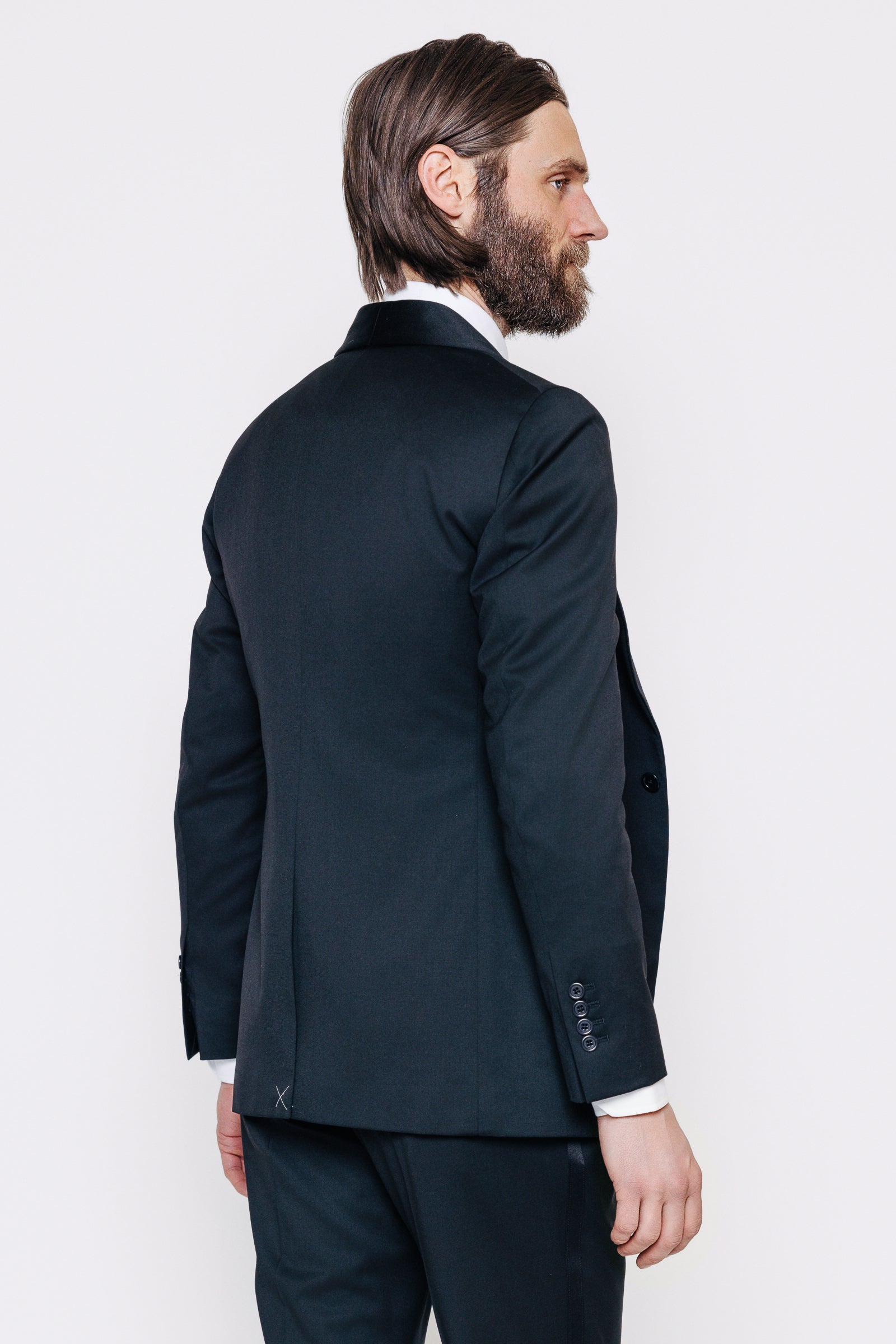 Maður í svörtum sérsaumuðum jakkafötum. Myndin sýnir bakhliðina á jakkanum.