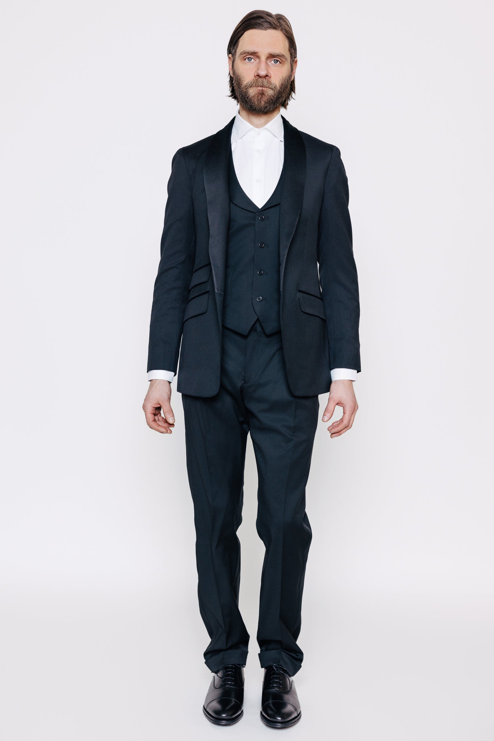 Herramaður í svörtum, sérsaumuðum jakkafötum. Jakka, vesti og buxum. Hvít skyrta og svartir spariskór.