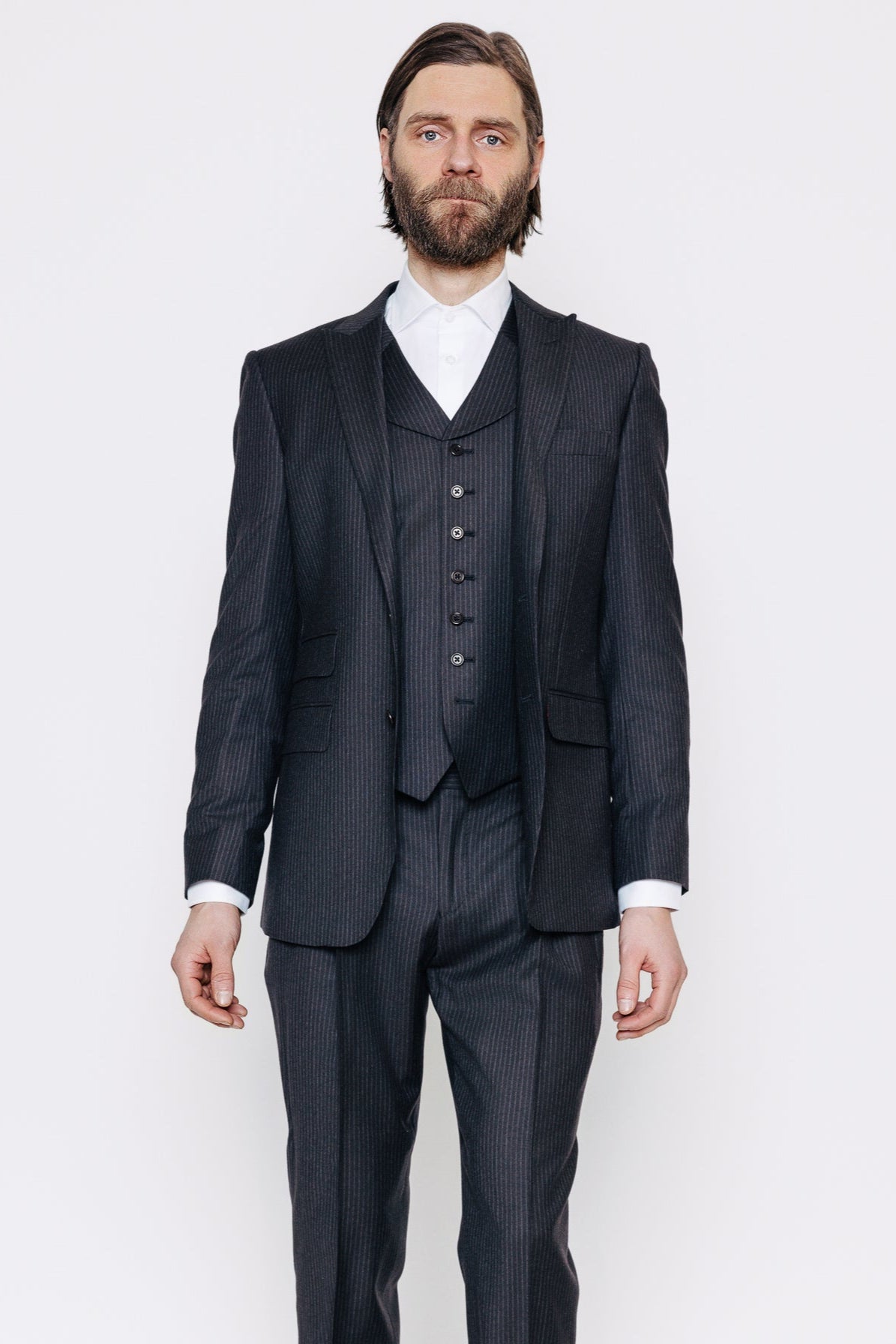 Maður í sérsaumuðum svörtum og gráum jakkafötum. Jakki, vesti og buxur.