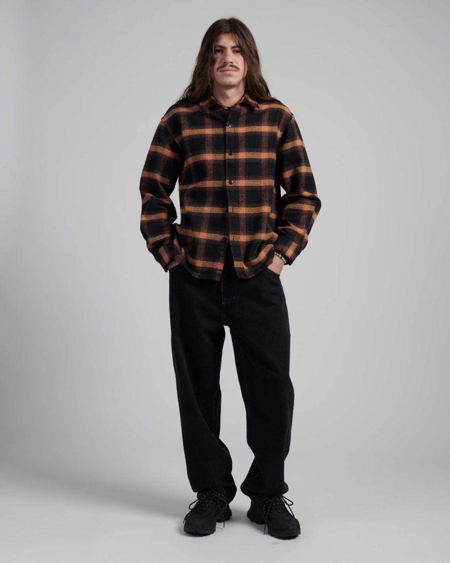 Model wearing the EDWIN Sebastian Shirt LS in brown and black plaid, styled with black pants.